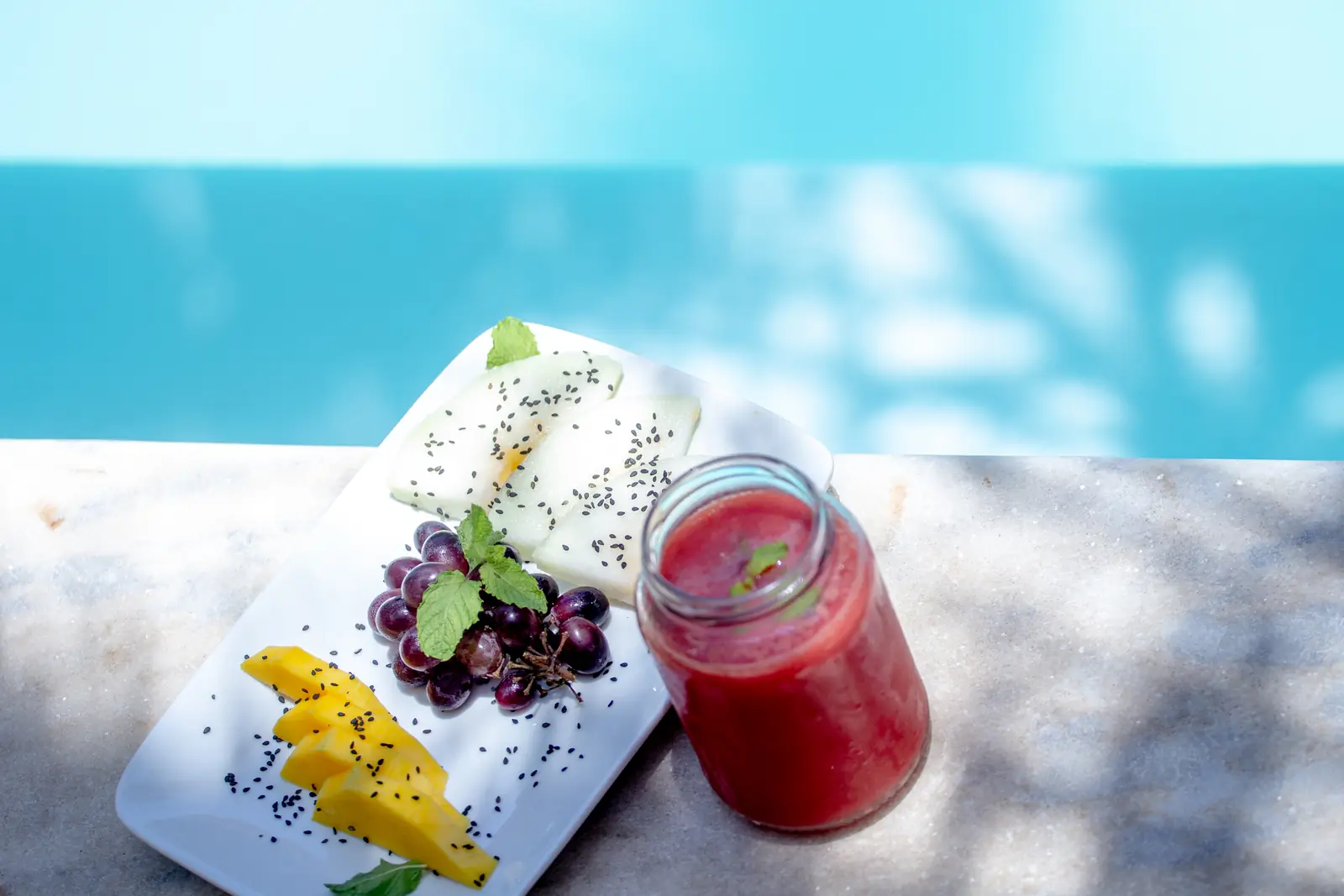 Frutas e suco servidos à beira da piscina